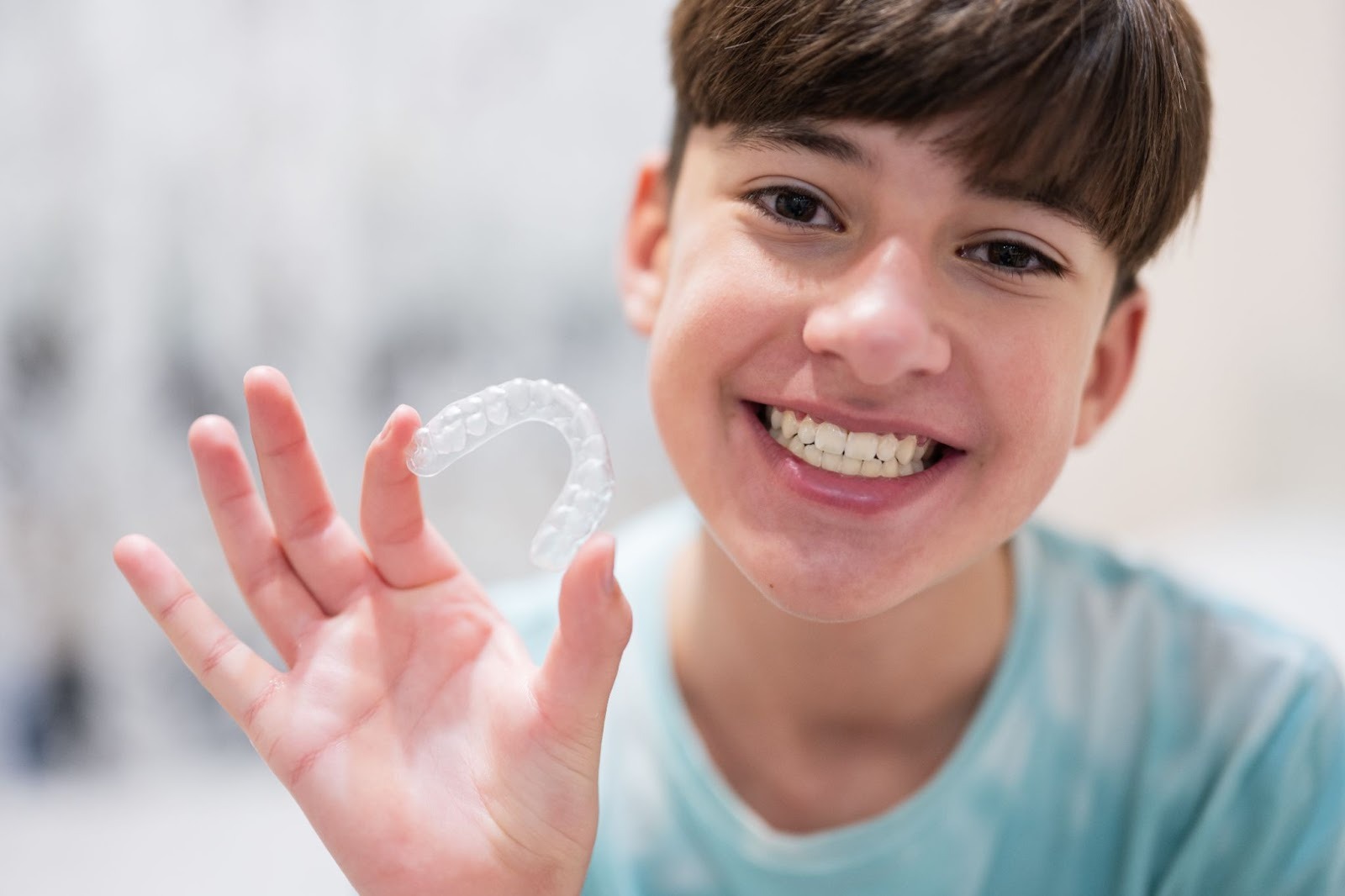 Best Invisalign Teeth Braces for Kids: A Comprehensive Guide to Invisalign Teen A Teen holding up his Invisalign Teen braces for kids
