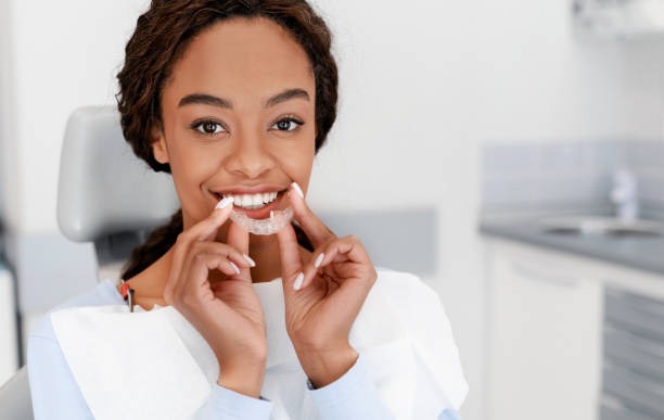 Woman preparing to wear her aligner, happy with her cost of Invisalign.