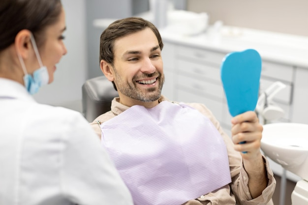 A smiling, happy man at our dentist office, visiting his family dentist near you.