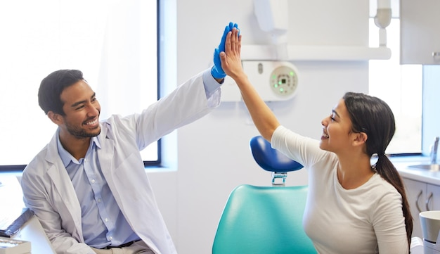 A laughing gas dentist giving a high five to a patient receiving nitrous oxide near you.