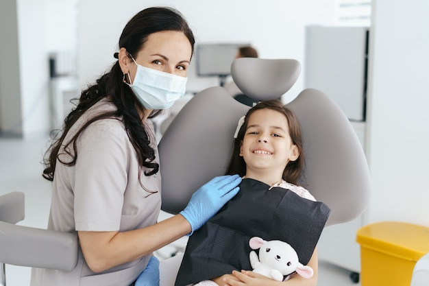 A dentist helping a child feel comfortable during a dental sedation visit.