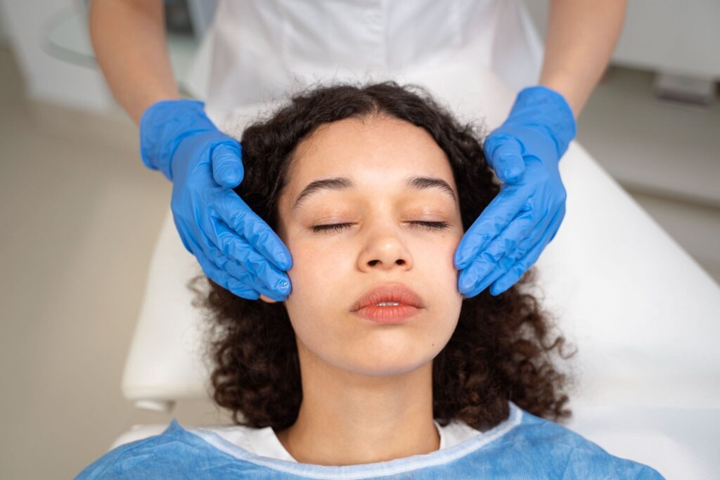 Dentist gently examining a relaxed patient’s face during a dental sedation procedure.