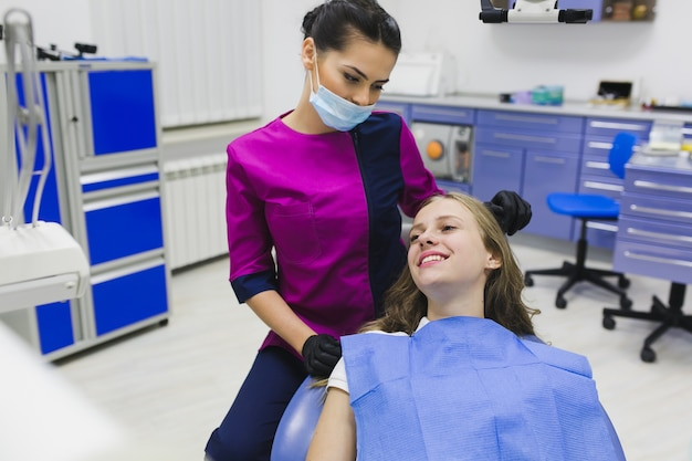 Dentist assisting a patient in a dental office with options such as zirconia dental implants, zirconia dental crowns, ceramic tooth crowns, and composite fillings.