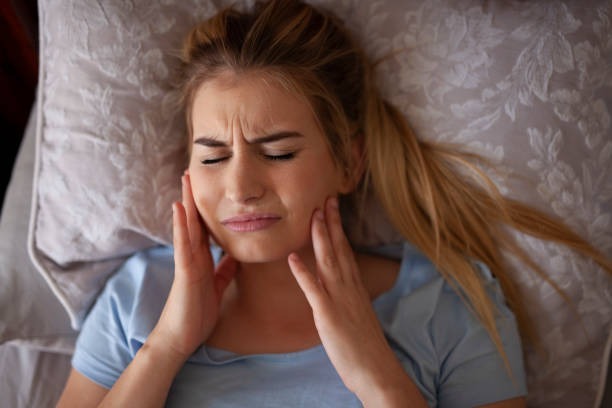 What is TMJ? Shown is a woman with a TMJ symptom disorder, needing TMJ treatment.