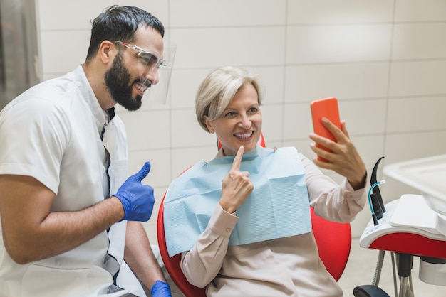Dentist for implants near you and a happy patient celebrating a successful implant tooth replacement.