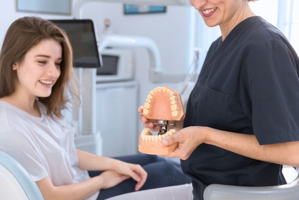A patient in implant dentistry, wondering how dental implants work, is shown a dental implant model.