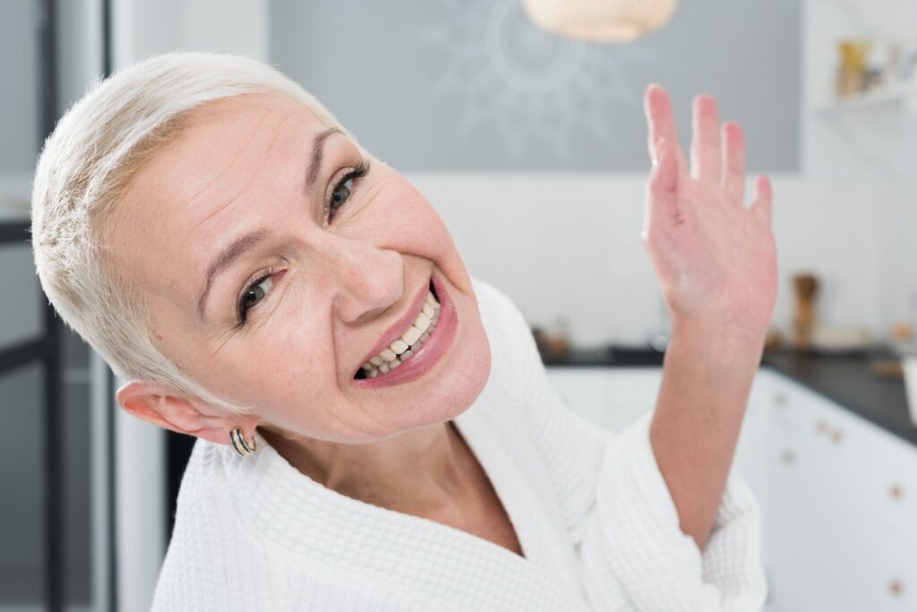 Happy woman smiling confidently, showcasing a healthy and bright smile, symbolizing the benefits of dental implants for restoring teeth and boosting self-confidence