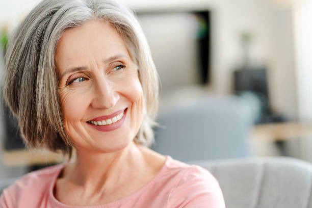Smiling older woman with dental implants, confidently showcasing her restored smile and increased self-confidence.