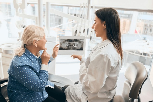 Dentist showing dental implant X-ray to patient during a dental implant consultation near you.