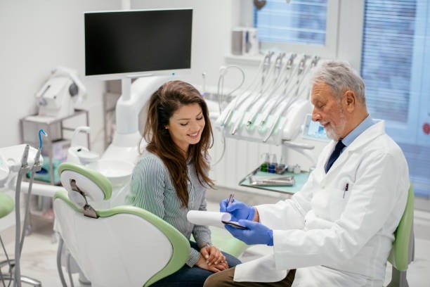 Smiling patient looking at affordable dental insurance plans presented by the dental team.