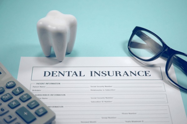 Close-up of documents outlining dental insurance and dental plans on a clinic desk.