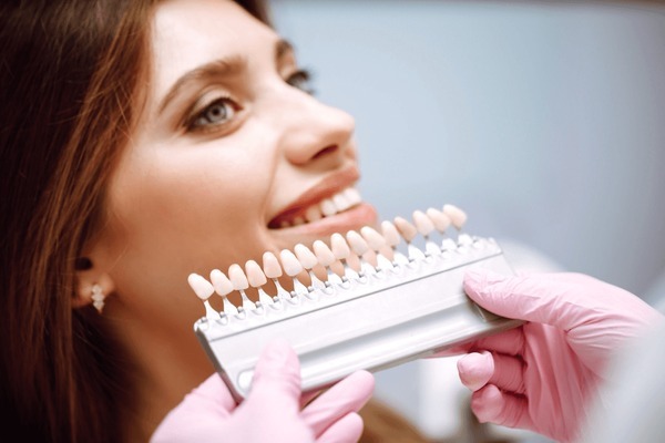 Dentist holding a porcelain veneer sample tray during a veneers cost consultation