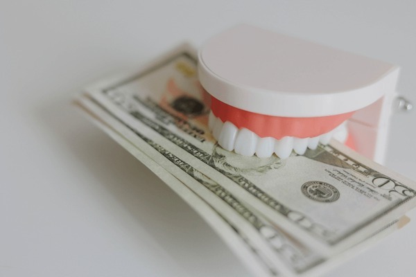 Teeth model with money saved with CareCredit.